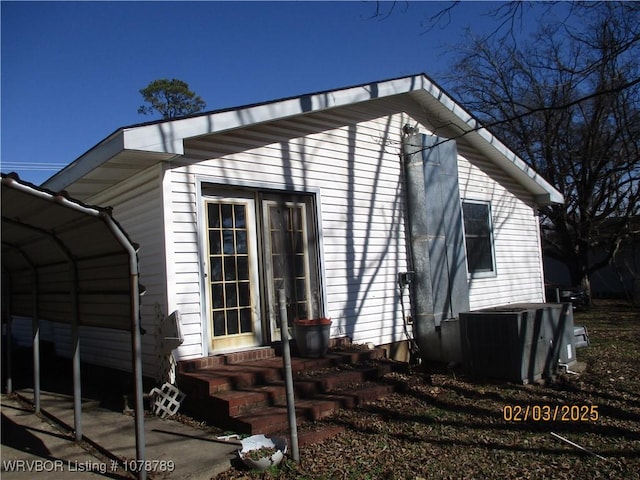 view of home's exterior featuring central AC unit and a carport