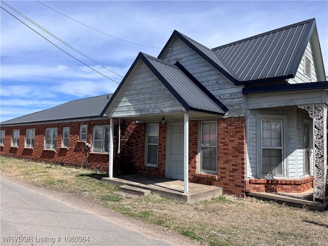 72 2nd St, Waldron, AR 72958 - view of side of property featuring brick siding and metal roof