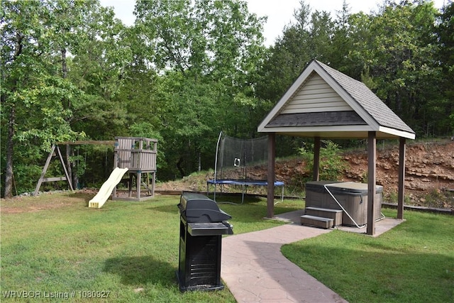 view of home's community featuring a trampoline, a jacuzzi, and a lawn
