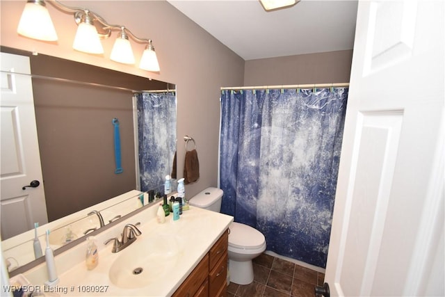 bathroom featuring toilet, vanity, and a shower with curtain