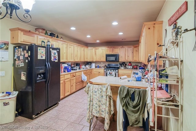 kitchen featuring light brown cabinetry, light tile patterned floors, a kitchen breakfast bar, and black appliances