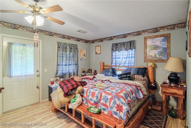 bedroom with multiple windows, ceiling fan, and light hardwood / wood-style flooring