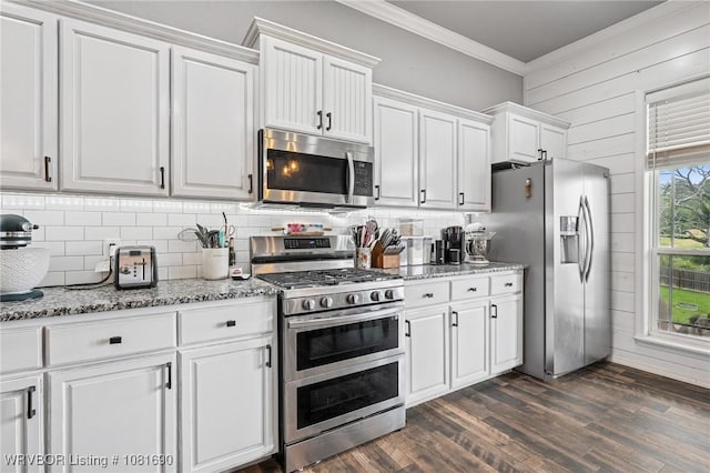 2207 Lisa Ln, Van Buren, AR 72956 - kitchen featuring appliances with stainless steel finishes, crown molding, white cabinets, decorative backsplash, and wood walls