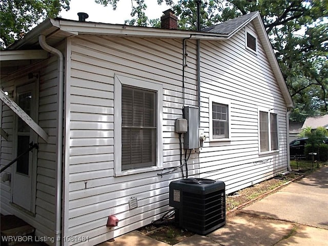 619 N 40th St, Fort Smith, AR 72903 - view of home's exterior featuring central air condition unit, a chimney, and a patio