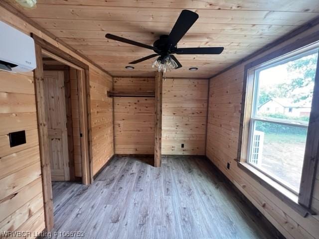 spare room featuring a wall mounted AC, wood walls, and wood ceiling