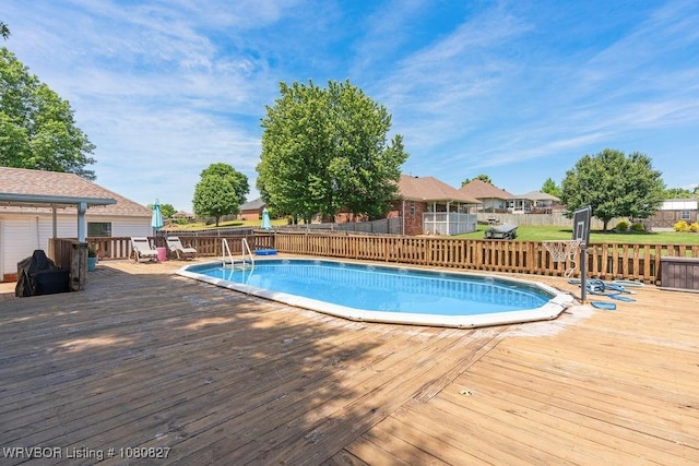 view of pool featuring a wooden deck, fence, and a residential view