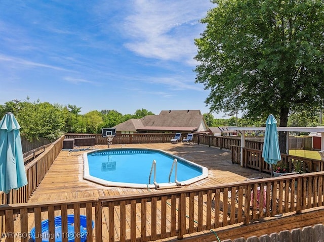 view of pool with a deck and fence