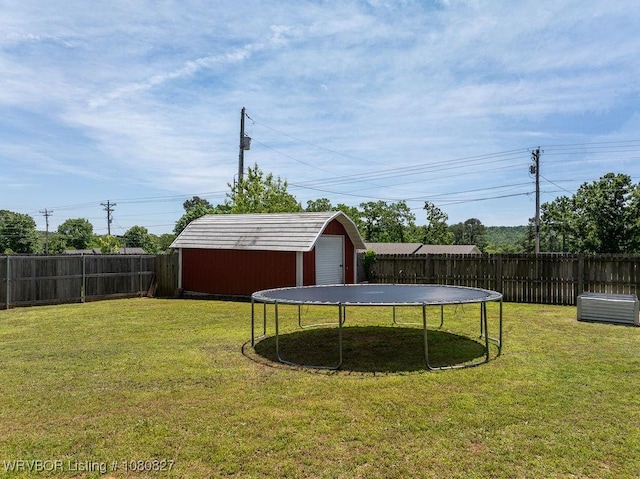 view of yard featuring a storage unit, a trampoline, an outdoor structure, and a garage