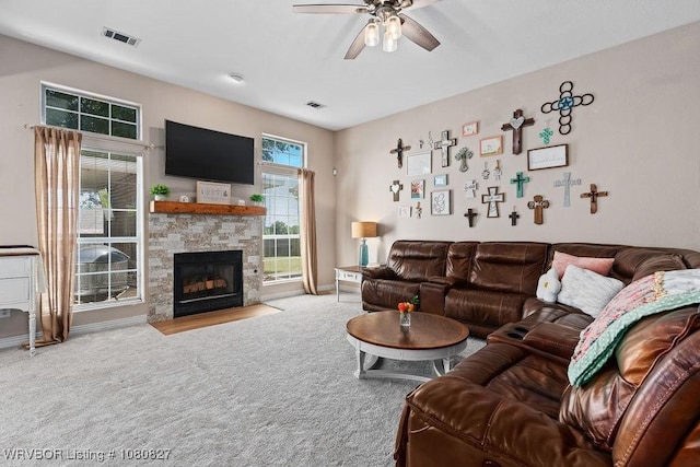 living room with carpet, a ceiling fan, a fireplace, and baseboards
