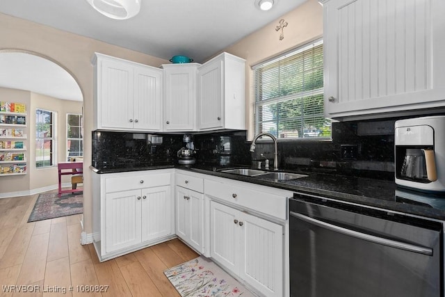 kitchen featuring dishwasher, a sink, decorative backsplash, and white cabinets