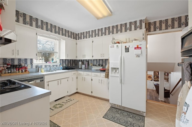 kitchen with white cabinetry, white fridge with ice dispenser, sink, and backsplash