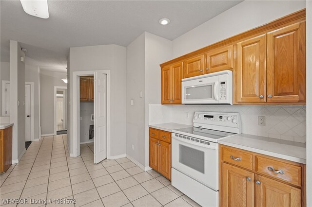 7004 Millennium Dr, Fort Smith, AR 72916 - kitchen with white appliances, light countertops, light tile patterned floors, decorative backsplash, and brown cabinets