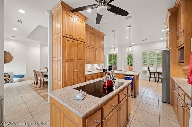 38 Jeffrey Way, Fort Smith, AR 72903 - kitchen with a kitchen island, black electric stovetop, light tile patterned flooring, freestanding refrigerator, and beverage cooler