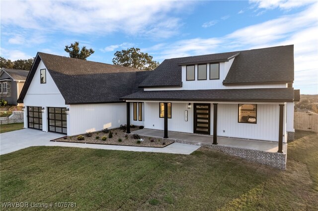 view of front of house with a front lawn, a porch, and a garage