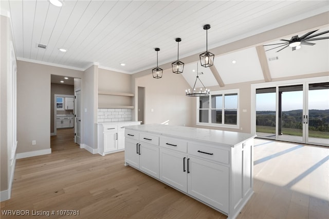 kitchen featuring light stone countertops, white cabinetry, lofted ceiling with beams, decorative light fixtures, and ceiling fan with notable chandelier