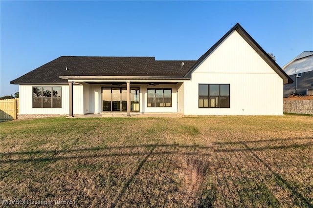 back of property with ceiling fan, a yard, and a patio