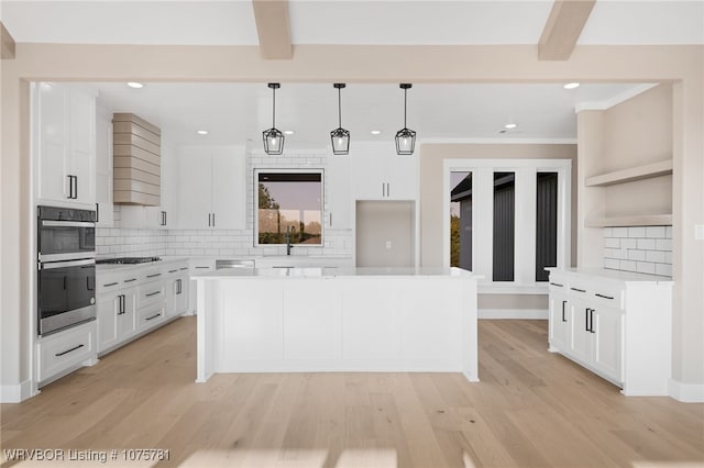 kitchen with white cabinets, decorative backsplash, double oven, beamed ceiling, and decorative light fixtures