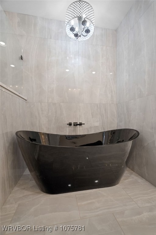 bathroom with a bathtub and a notable chandelier