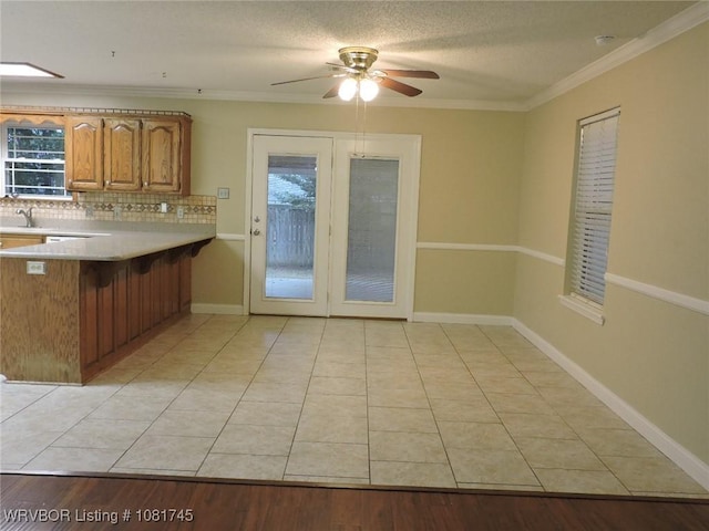 2211 Breckenridge Ter, Greenwood, AR 72936 - kitchen featuring decorative backsplash, light countertops, a breakfast bar, plenty of natural light, and crown molding