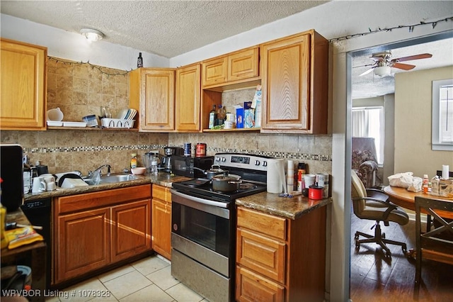 kitchen featuring a textured ceiling, decorative backsplash, stainless steel range with electric stovetop, ceiling fan, and light tile patterned floors