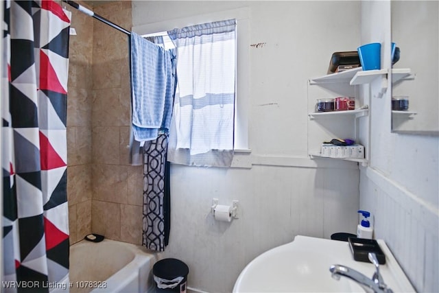 bathroom featuring shower / bath combo with shower curtain and sink