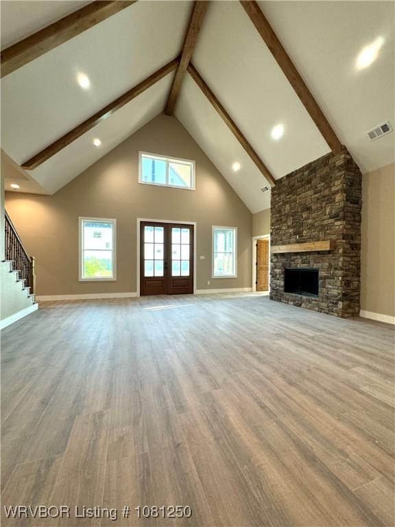 4457 Radio Tower Rd, Van Buren, AR 72956 - unfurnished living room with high vaulted ceiling, wood finished floors, beam ceiling, baseboards, and a stone fireplace