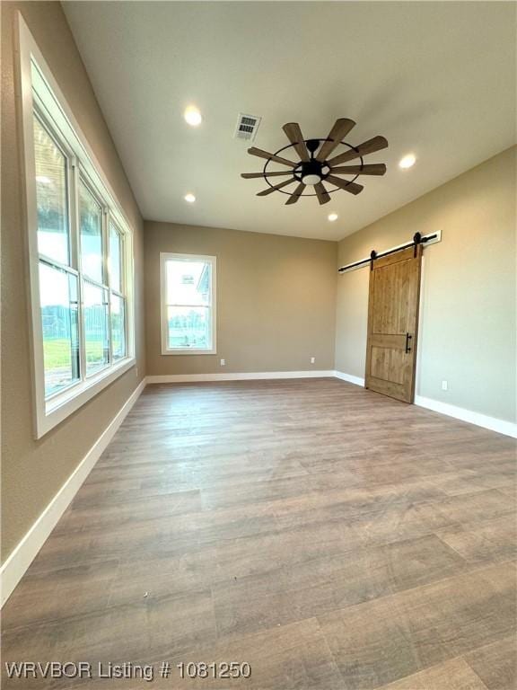 4457 Radio Tower Rd, Van Buren, AR 72956 - empty room featuring a barn door, recessed lighting, baseboards, wood finished floors, and a ceiling fan
