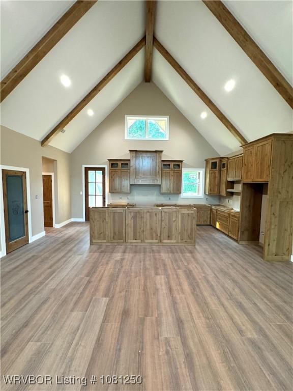 4457 Radio Tower Rd, Van Buren, AR 72956 - kitchen with high vaulted ceiling, beamed ceiling, light wood finished floors, glass insert cabinets, and baseboards