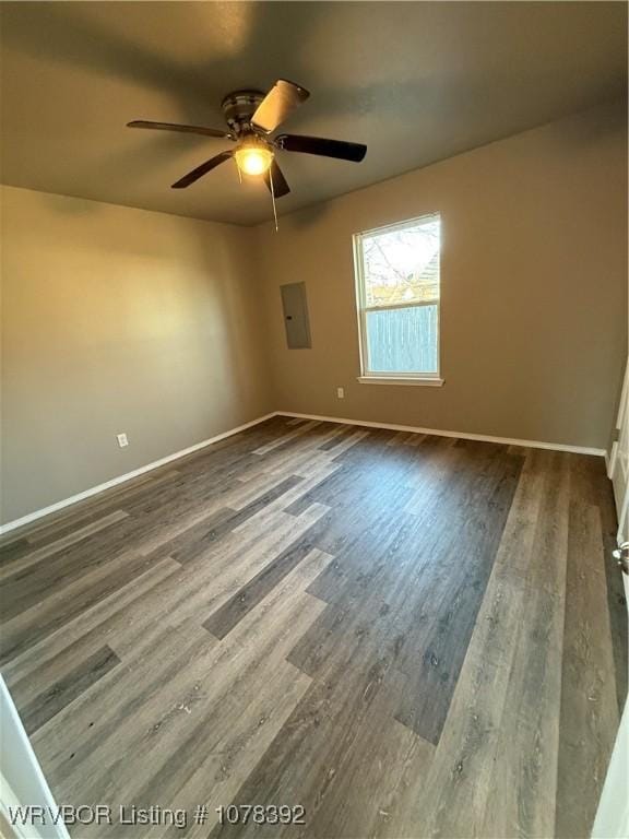 unfurnished room with ceiling fan, electric panel, and dark hardwood / wood-style floors