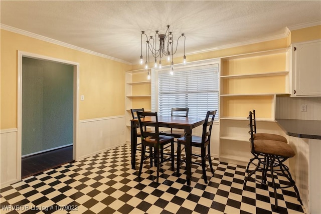 dining area featuring a notable chandelier, ornamental molding, and a textured ceiling