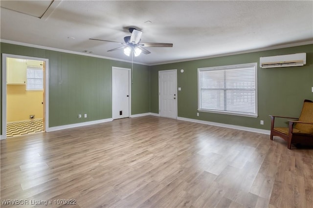 interior space featuring ceiling fan, ornamental molding, a wall mounted air conditioner, and light hardwood / wood-style flooring