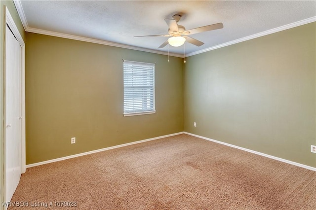 spare room with a textured ceiling, ornamental molding, ceiling fan, and carpet