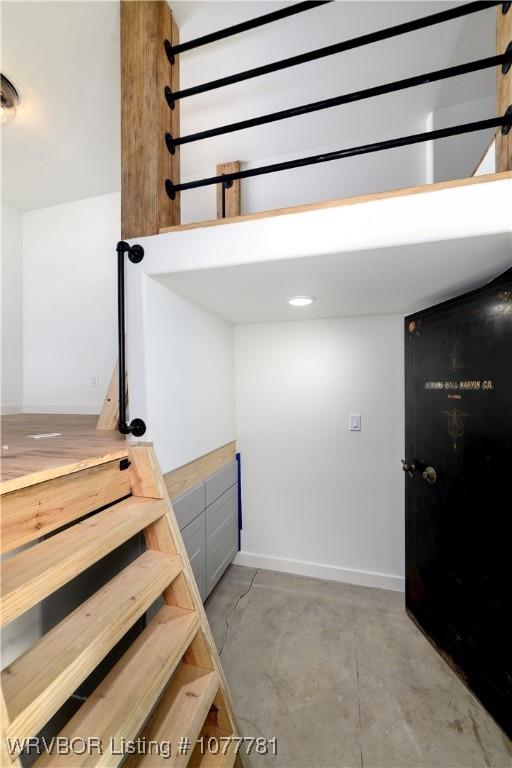 staircase featuring concrete floors