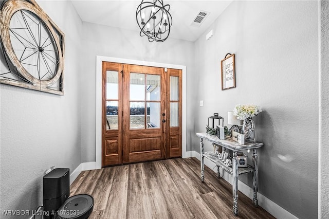 entryway featuring wood-type flooring and a notable chandelier