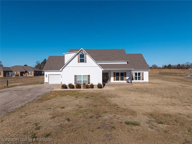 back of house with a lawn and a garage