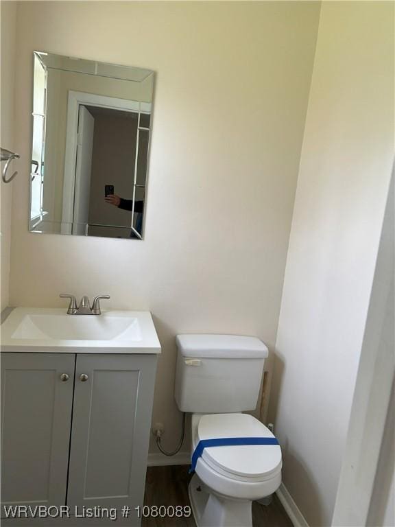 102 Gamma Cir, Roland, OK 74954 - half bathroom featuring vanity, baseboards, toilet, and wood finished floors
