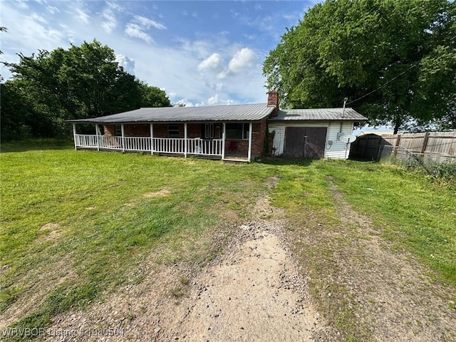 view of front of house with dirt driveway, a chimney, fence, brick siding, and a front yard