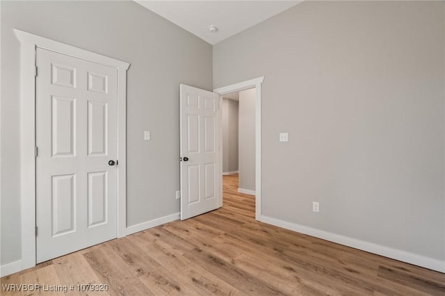 unfurnished bedroom with baseboards and wood finished floors