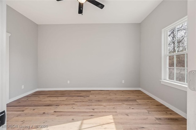 spare room with light wood-type flooring, baseboards, and a ceiling fan