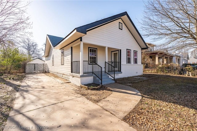 bungalow-style home featuring crawl space, driveway, and a porch