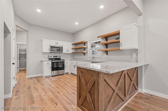 kitchen featuring light stone counters, white cabinets, stainless steel appliances, and open shelves