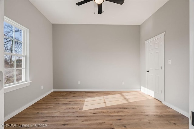 unfurnished room featuring wood finished floors, baseboards, and ceiling fan