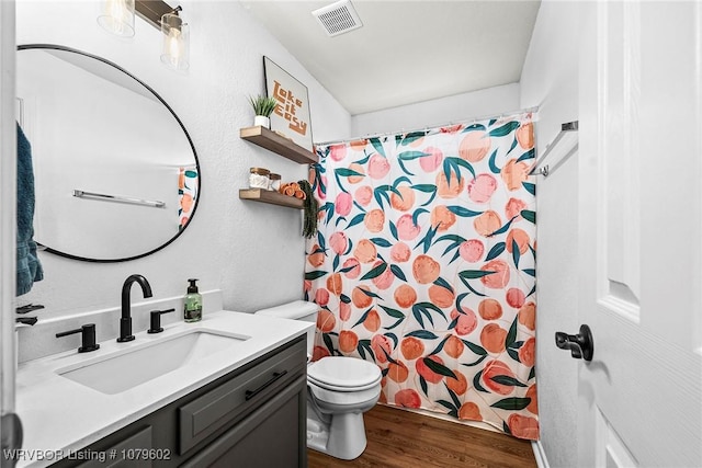 full bathroom with visible vents, toilet, curtained shower, wood finished floors, and vanity