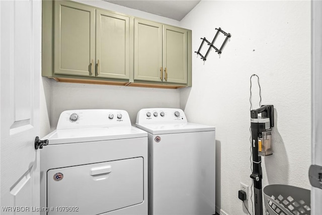 washroom featuring washing machine and dryer and cabinet space