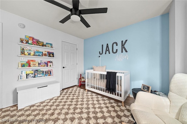 bedroom featuring a crib and ceiling fan