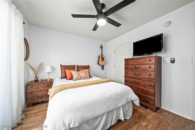 bedroom with baseboards, wood finished floors, and a ceiling fan