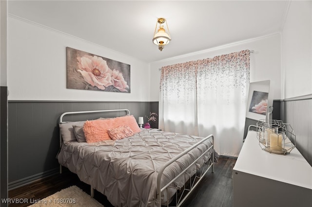 bedroom featuring crown molding, wainscoting, and dark wood-style floors