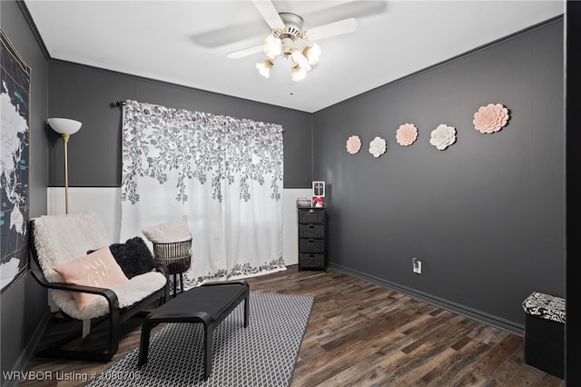 sitting room featuring baseboards, ceiling fan, and dark wood-style floors