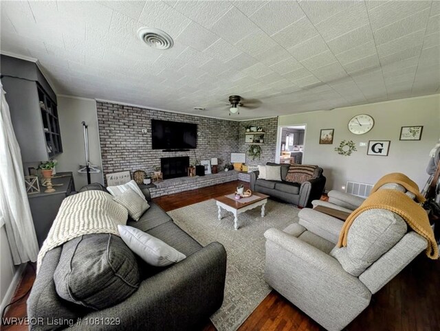 1385 Old Airport Rd, Paris, AR 72855 - living room with dark wood-style flooring, ceiling fan, a fireplace, and brick wall