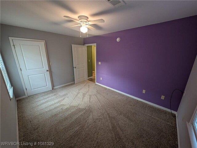 1385 Old Airport Rd, Paris, AR 72855 - unfurnished bedroom with carpet, baseboards, ceiling fan, and multiple windows